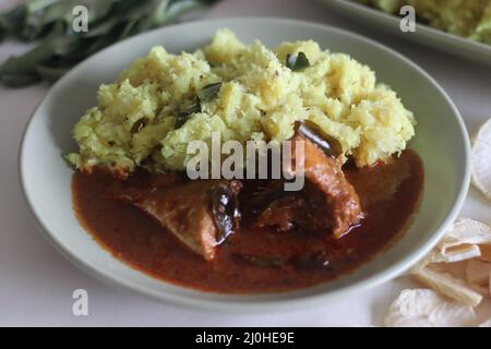 Purée de casava sec ou tapioca sec avec noix de coco râpée, échalotes, piments, curcuma et feuilles de curry. Servi avec du curry de maquereau épicé rouge. Populaire dis Banque D'Images