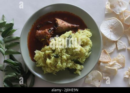 Purée de casava sec ou tapioca sec avec noix de coco râpée, échalotes, piments, curcuma et feuilles de curry. Servi avec du curry de maquereau épicé rouge. Populaire dis Banque D'Images