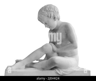 Ancienne statue en marbre d'un garçon assis. Jeune homme sculpture isolée sur fond blanc. Monument en pierre antique Banque D'Images