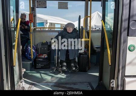 Une femme âgée en fauteuil roulant attend dans un bus pour être transférée à la ville de Suceava, la plus grande ville près de la frontière. Environ 3 mille personnes arrivent quotidiennement à Siret, en Roumanie, pour se réfugier contre la violence causée par la guerre entre la Russie et l'Ukraine. Dans cette ville frontalière, un couloir d'aide humanitaire a été organisé entre diverses organisations civiles et étatiques. Les personnes qui fuient l'Ukraine sont principalement des femmes, des enfants et des adultes plus âgés. Lorsqu'ils franchissent la frontière, les gens reçoivent de l'aide médicale, psychologique, alimentaire, de transport et d'hébergement. Grâce à l'aide des bénévoles, ces gens le peuvent Banque D'Images