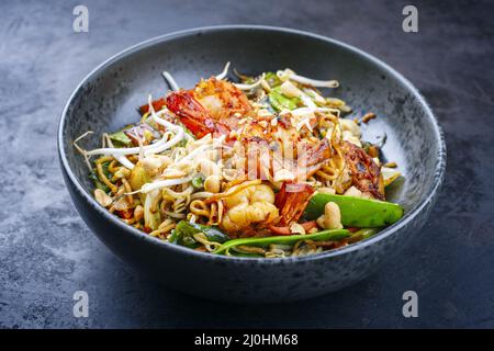 Curry traditionnel thaïlandais de style moderne avec crevettes géantes et nouilles au barbecue, dans un bol de style nordique avec copie Banque D'Images