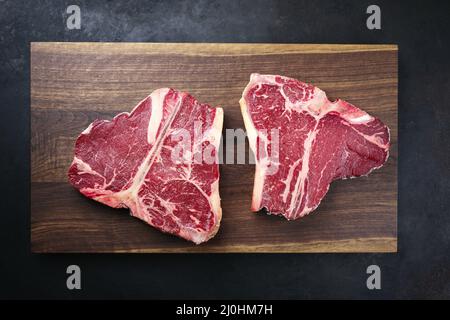 Deux steaks de bœuf Wagyu vieilli et sec sont offerts comme vue de dessus sur un panneau en bois de noix de conception moderne Banque D'Images