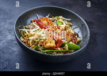 Curry traditionnel thaïlandais de style moderne avec crevettes géantes et nouilles au barbecue, dans un bol de style nordique avec copie Banque D'Images