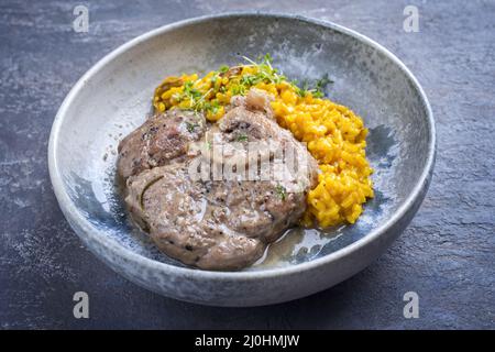 Style moderne traditionnel italien braisé ossobuco alla milanais avec risotto au safran et herbes dans la sauce de viande de vin blanc servi un Banque D'Images