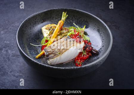 Filet de cabillaud frit traditionnel de style moderne avec fenouil et crème de tomate servi en gros plan dans un bol en céramique avec Banque D'Images