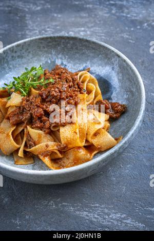 Sauce bolognaise au ragu italien traditionnel de style moderne avec pâtes papedelles et parmesan servi en gros plan Banque D'Images