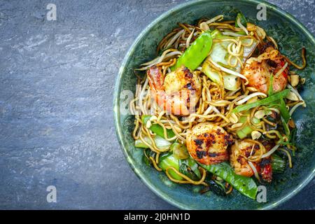 Curry traditionnel thaïlandais de style moderne avec crevettes géantes et nouilles au barbecue, vue imprenable sur un bol de style nordique avec copie Banque D'Images