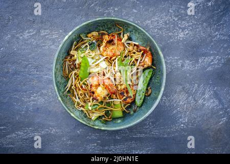 Curry traditionnel thaïlandais de style moderne avec crevettes géantes et nouilles au barbecue, vue imprenable sur un bol de style nordique avec copie Banque D'Images