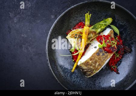 Filet de cabillaud frit traditionnel de style moderne avec fenouil et crème de tomate servi en gros plan dans un bol en céramique avec Banque D'Images