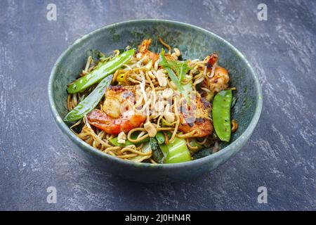 Curry traditionnel thaïlandais de style moderne avec crevettes géantes et nouilles au barbecue, dans un bol de style nordique avec copie Banque D'Images