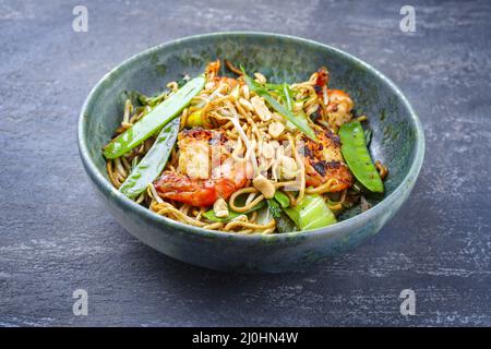 Curry traditionnel thaïlandais de style moderne avec crevettes géantes et nouilles au barbecue, dans un bol de style nordique avec copie Banque D'Images