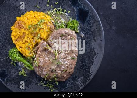 Style moderne traditionnel italien braisé ossobuco alla milanais avec risotto au safran et bébé brocoli dans une sauce à la viande au vin blanc Banque D'Images