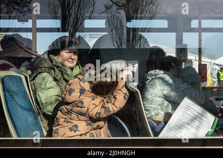 18 mars 2022, Siret, Roumanie : une femme avec un passeport en main est à bord d'un bus qui attend d'entrer en Europe centrale. Environ 3 mille personnes arrivent quotidiennement à Siret, en Roumanie, pour se réfugier contre la violence causée par la guerre entre la Russie et l'Ukraine. Dans cette ville frontalière, un couloir d'aide humanitaire a été organisé entre diverses organisations civiles et étatiques. Les personnes qui fuient l'Ukraine sont principalement des femmes, des enfants et des adultes plus âgés. Lorsqu'ils franchissent la frontière, les gens reçoivent de l'aide médicale, psychologique, alimentaire, de transport et d'hébergement. Grâce à l'aide des bénévoles, ces gens peuvent prendre une br Banque D'Images