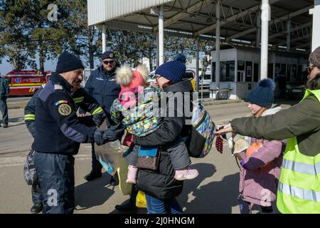 19 mars 2022, Siret, Roumanie : la police des frontières roumaine à Siret reçoit une famille après avoir traversé la frontière. Environ 3 mille personnes arrivent quotidiennement à Siret, en Roumanie, pour se réfugier contre la violence causée par la guerre entre la Russie et l'Ukraine. Dans cette ville frontalière, un couloir d'aide humanitaire a été organisé entre diverses organisations civiles et étatiques. Les personnes qui fuient l'Ukraine sont principalement des femmes, des enfants et des adultes plus âgés. Lorsqu'ils franchissent la frontière, les gens reçoivent de l'aide médicale, psychologique, alimentaire, de transport et d'hébergement. Grâce à l'aide des bénévoles, ces personnes peuvent prendre une pause et Banque D'Images