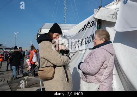 18 mars 2022, Siret, Roumanie : une femme est réunie avec sa mère et son chien après avoir quitté l'Ukraine. Environ 3 mille personnes arrivent quotidiennement à Siret, en Roumanie, pour se réfugier contre la violence causée par la guerre entre la Russie et l'Ukraine. Dans cette ville frontalière, un couloir d'aide humanitaire a été organisé entre diverses organisations civiles et étatiques. Les personnes qui fuient l'Ukraine sont principalement des femmes, des enfants et des adultes plus âgés. Lorsqu'ils franchissent la frontière, les gens reçoivent de l'aide médicale, psychologique, alimentaire, de transport et d'hébergement. Grâce à l'aide des bénévoles, ces gens peuvent faire une pause et gagner Banque D'Images