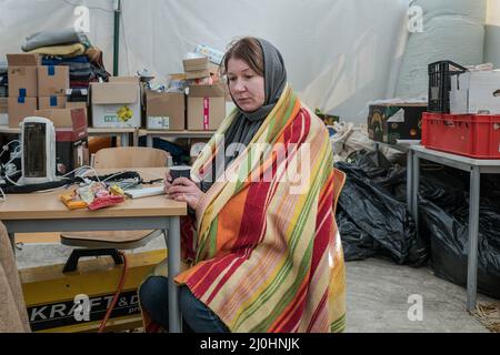 18 mars 2022, Siret, Roumanie : une femme se repose, boit quelque chose de chaud et continue ensuite son voyage en Europe centrale. Elle a reçu l'aide de la lutte pour la liberté, une organisation locale qui aide actuellement les réfugiés de la guerre. Environ 3 mille personnes arrivent quotidiennement à Siret, en Roumanie, pour se réfugier contre la violence causée par la guerre entre la Russie et l'Ukraine. Dans cette ville frontalière, un couloir d'aide humanitaire a été organisé entre diverses organisations civiles et étatiques. Les personnes qui fuient l'Ukraine sont principalement des femmes, des enfants et des adultes plus âgés. En traversant la frontière, les gens reçoivent des soins médicaux, psy Banque D'Images