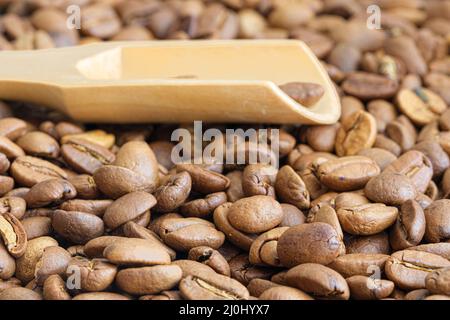 Fond de grains de café. Photo macro des grains de café turcs avec une cuillère en bois. Banque D'Images