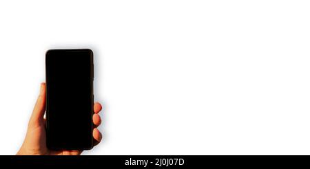 Homme tenant main smartphone avec écran noir vide gros plan isolé sur fond blanc. Grand espace de copie, espace vide pour les publicités ou les textes publicitaires. Banque D'Images