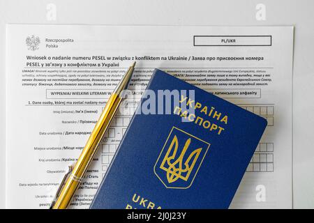 Document PESEL, passeport ukrainien et stylo sur fond de table blanc. Banque D'Images