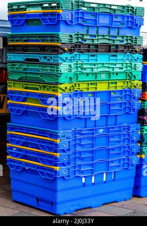 Epsom Surrey Londres, Royaume-Uni, mars 19 2022, pile de boîtes vides en plastique coloré de transport alimentaire à Un marché sans personne Banque D'Images