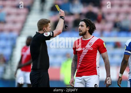 Wigan, Royaume-Uni. 19th mars 2022. Cole Stockton de Morecambe reçoit une carte jaune de l'arbitre James Oldham. EFL Skybet football League One Match, Wigan Athletic v Morecambe FC à Wigan, Lancs, le samedi 19th mars 2022. Cette image ne peut être utilisée qu'à des fins éditoriales. Utilisation éditoriale uniquement, licence requise pour une utilisation commerciale. Aucune utilisation dans les Paris, les jeux ou les publications d'un seul club/ligue/joueur. photo par Chris Stading/Andrew Orchard sports Photography/Alamy Live News crédit: Andrew Orchard sports Photography/Alamy Live News Banque D'Images