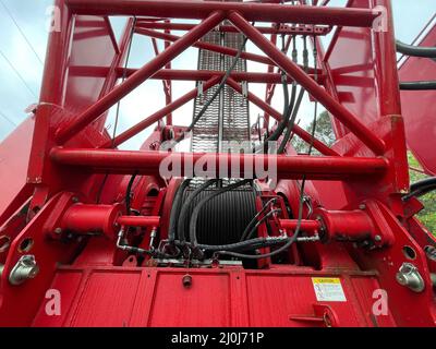 Augusta, GA USA - 03 19 22: Grue rouge Manitowoc scène de construction ciel pluvieux jour bobine de câble Banque D'Images