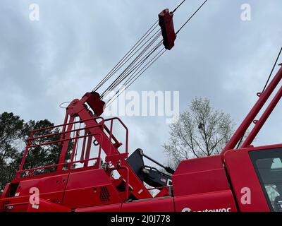 Augusta, GA USA - 03 19 22: Grue rouge Manitowoc scène de construction ciel et câbles de jour pluvieux nuageux Banque D'Images