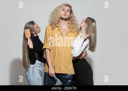 Groupe de beauté femmes et hommes peignant des soins de cheveux sains, modèles de cheveux. Mode, beauté, cosmétiques, coiffure, cheveux en peigne et cheveux. Banque D'Images