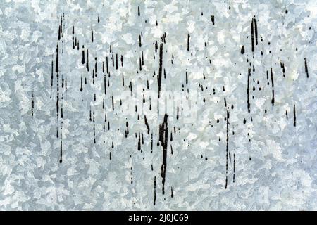 Fond argenté sous forme de feuille d'acier galvanisé texturé avec des gouttes noires de résine. Banque D'Images