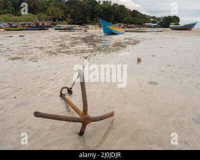 Kaimana, Arguni Bay, Indonésie - février 2018 : bateaux en bois colorés sur la plage à marée basse au port d'une petite ville sur la tête d'oiseau Peninsul Banque D'Images