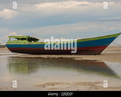 Kaimana, Arguni Bay, Indonésie - février 2018 : bateaux en bois colorés sur la plage à marée basse au port d'une petite ville sur la tête d'oiseau Peninsul Banque D'Images