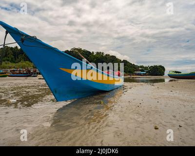 Kaimana, Arguni Bay, Indonésie - février 2018 : bateaux en bois colorés sur la plage à marée basse au port d'une petite ville sur la tête d'oiseau Peninsul Banque D'Images