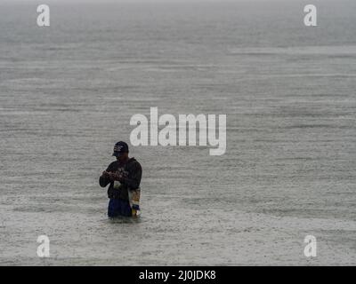 Kaimana, Indonésie - 7 février 2018 : silhouette de pêcheur à marée haute sur la mer de Saram. Kaimana, péninsule de Bird's Head, Papouasie occidentale, Indonésie Banque D'Images