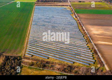 Vue aérienne d'un parc solaire avec des modules PV d'un système au sol au milieu de l'agriculture rurale Banque D'Images