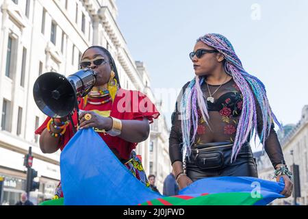 Manifestation contre le racisme dans les rues de Londres. Deux femmes noires vivent des manifestants qui parlent dans un mégaphone. Londres - 19th mars 2022 Banque D'Images