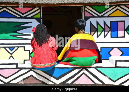 Les femmes Ndebele et hut à Motseng Village culturel, Sun City Resort, Pilanesberg, Province du Nord Ouest de la République d Afrique du Sud Banque D'Images