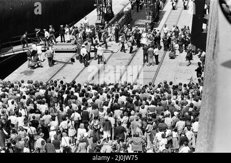 QE2 revient à Southampton. Les Union Jacks sont festoonés sur les voitures, drapés sur les épaules, ondulés sur des bâtons. Southampton donne un accueil « Three Cheers » au paquebot de luxe QE2 devenu trooper de retour de la guerre. À bord se trouve sa précieuse cargaison, les 700 survivants du HMS Coventry, ardent et antilope, qui ont sombré dans la bataille pour les Malouines. 11th juin 1982. Banque D'Images