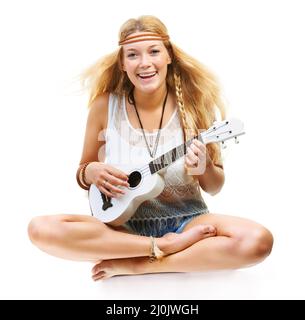 Alerte hippy. Studio photo d'un enfant floral attrayant jouant une guitare isolée sur blanc. Banque D'Images