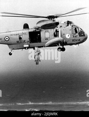 Une RAF recherche et sauvetage Sea King de RAF Boulmer treuil un homme à bord le piller hors de la mer au large de Cullercoats. L'hélicoptère avait été impliqué dans le double sauvetage à grands vents qui avait commencé avec un chavirement de bateau de pêche suivi par le bateau de sauvetage faisant de même. Deux hommes ont été sauvés par le Sea King, un autre homme a réussi à nager de nouveau vers le rivage un quatrième noyé piégé par les algues et la corde du bateau. 22/02/1981. Banque D'Images