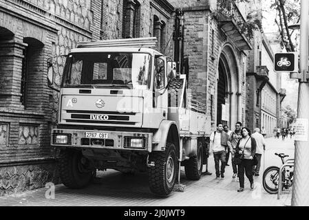Photo en niveaux de gris d'un gros camion Iveco Eurocargo livrant dans la ville. Barcelone, Espagne Banque D'Images