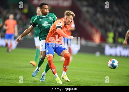 Brême, Allemagne. 19th mars 2022. Football: 2nd Bundesliga, Werder Bremen - Darmstadt 98, Matchday 27, wohninvest Weserstadion. Felix Agu de Werder (l) lutte pour le ballon contre Tim Skarkeum de Darmstadt. Crédit : Carmen Jaspersen/dpa - REMARQUE IMPORTANTE : Conformément aux exigences de la DFL Deutsche Fußball Liga et de la DFB Deutscher Fußball-Bund, il est interdit d'utiliser ou d'avoir utilisé des photos prises dans le stade et/ou du match sous forme de séquences et/ou de séries de photos de type vidéo./dpa/Alay Live News Banque D'Images