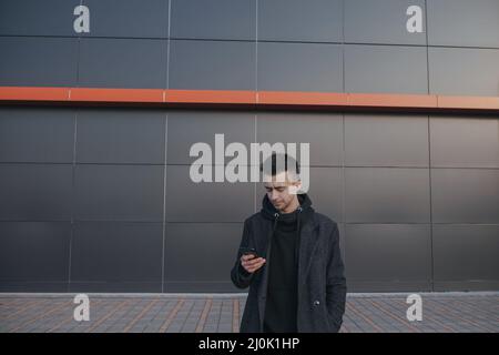 jeune ukrainien homme regarder dans le téléphone et écrire des sms Banque D'Images