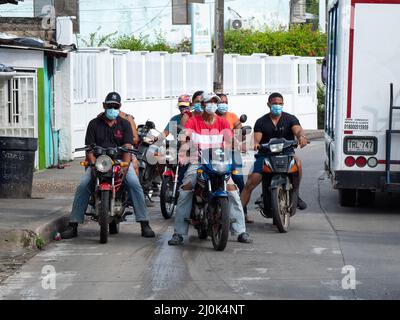 San Andrés, San Andrés y Providencia, Colombie - novembre 17 2021: Plusieurs Black Man et femme à visage masques sur Motorcycles attendent dans la rue à a Banque D'Images