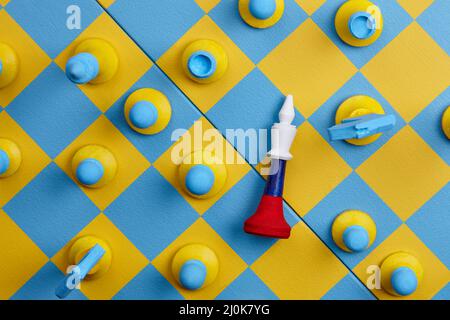 Jeux d'échecs de couleurs nationales ukrainiennes et russes sur plateau bleu et jaune Banque D'Images