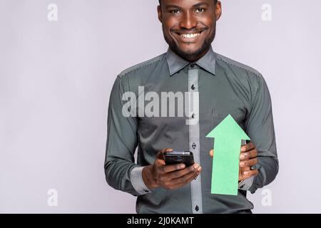 Homme tenant le téléphone et la flèche pointant vers le haut montrant les progrès et le succès Banque D'Images