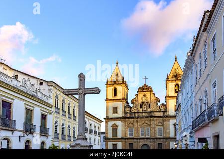 Vieilles maisons et églises de style colonial et baroque avec un crucifix sur la place centrale du Pelourinho Banque D'Images