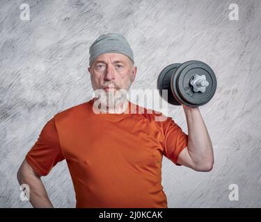 portrait décontracté de l'homme barbu ancien (fin 60s) s'exerçant avec des haltères lourdes, senior actif et concept de fitness Banque D'Images