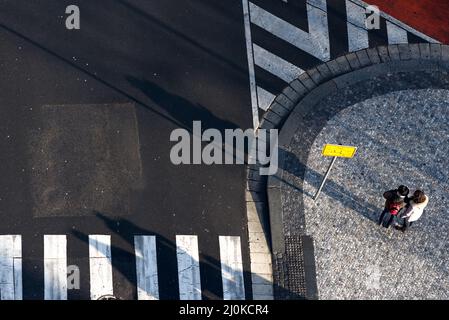 Deux personnes par signpost se trouvant à leur chemin dans une ville. Vue grand angle Banque D'Images
