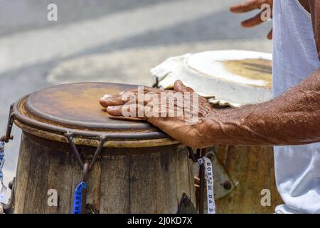 Musicien jouant un instrument brésilien traditionnel de percussion appelé atabaque pendant une performance de capoeira Banque D'Images