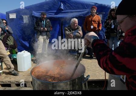 19 mars 2022, Siret, Roumanie : un groupe de volontaires prépare la nourriture qu'ils donnent quotidiennement aux personnes qui traversent la frontière. Environ 3 mille personnes arrivent quotidiennement à Siret, en Roumanie, pour se réfugier contre la violence causée par la guerre entre la Russie et l'Ukraine. Dans cette ville frontalière, un couloir d'aide humanitaire a été organisé entre diverses organisations civiles et étatiques. Les personnes qui fuient l'Ukraine sont principalement des femmes, des enfants et des adultes plus âgés. Lorsqu'ils franchissent la frontière, les gens reçoivent de l'aide médicale, psychologique, alimentaire, de transport et d'hébergement. Grâce à l'aide des bénévoles, ces gens peuvent prendre Banque D'Images